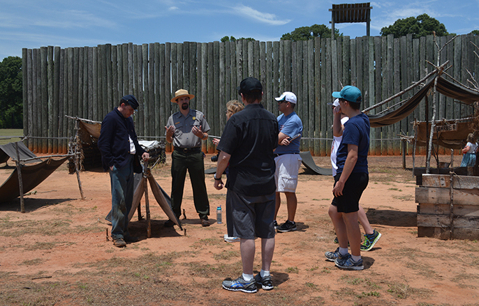 Living historian and park ranger talk to visitors in the prison site