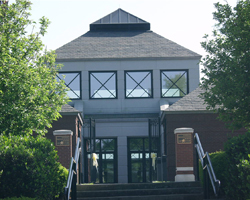 Museum building framed by green trees