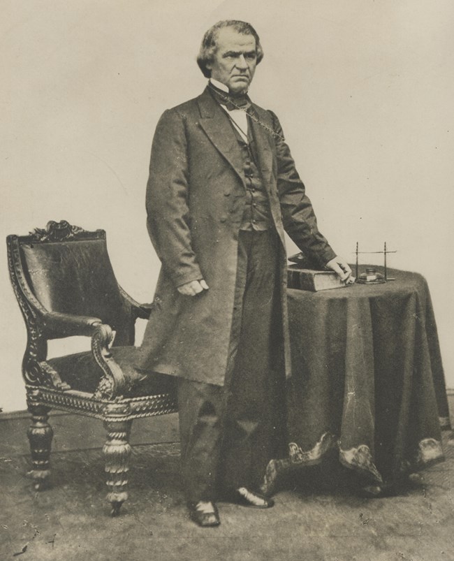 Andrew Johnson image made by Matthew Brady with Johnson standing by a table