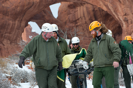Park staff carry an injured visitor from Double Arch to a waiting ambulance.