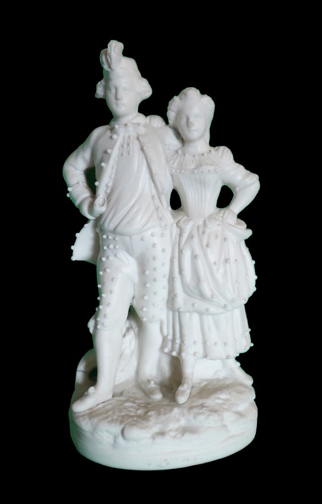 A white figurine of a young Scottish couple