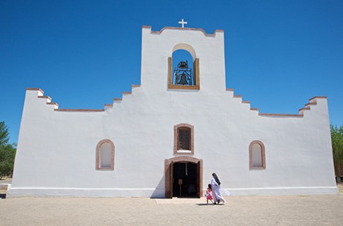 The massive stair-stepped facade of Socorro Mission rises in the west Texas skyline in an abstract echoing of Pueblo pottery cloud designs. Photo © Jack Parsons