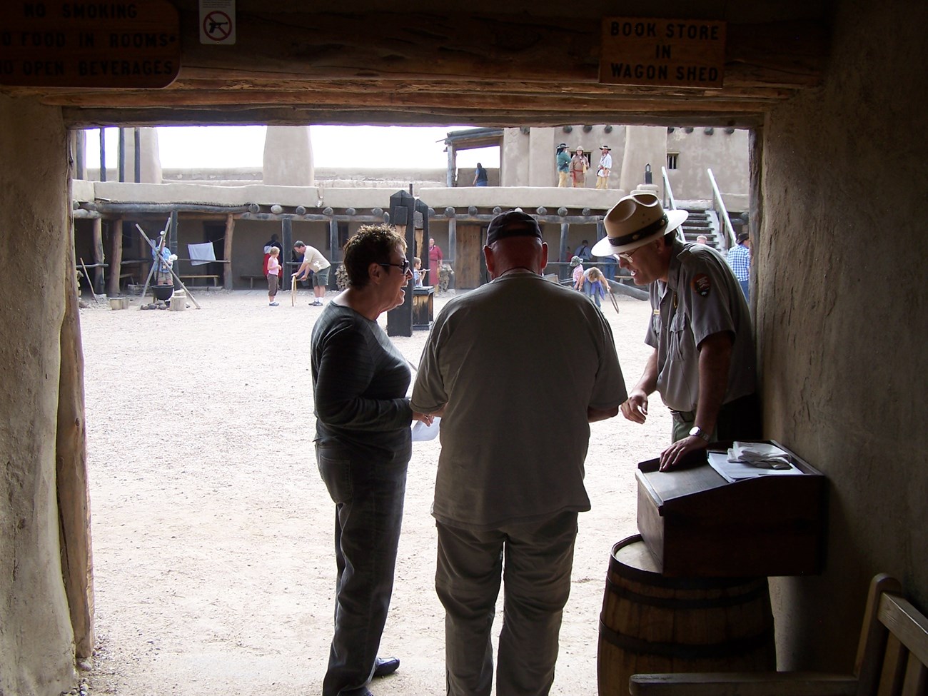 A park ranger interacts with visitors as they enter the plaza at Bent's Old Fort.