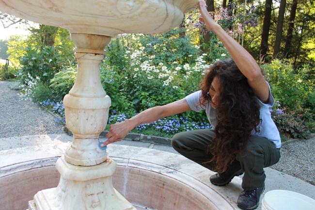 Maintenance worker cleans historic fountain
