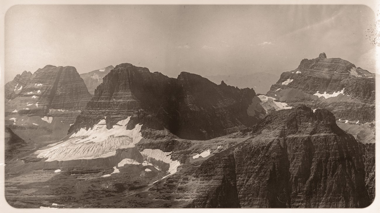 Black and white image of a steep mountainous landscape with a glacier on the left side.