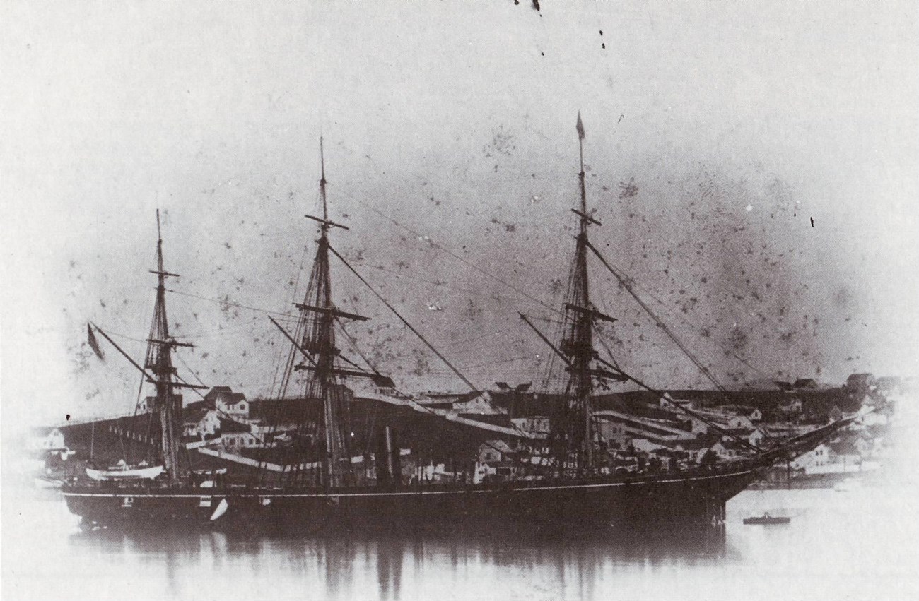 Black and white photograph of a three-mast ship.