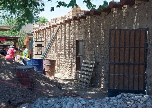 The thick exposed adobe walls of the 1850’s jail house on Main Street, undergoing restoration here, were not strong enough to keep Billy the Kid from helping his friend Melquiadez Segura escape in 1876. Photo © Jack Parsons