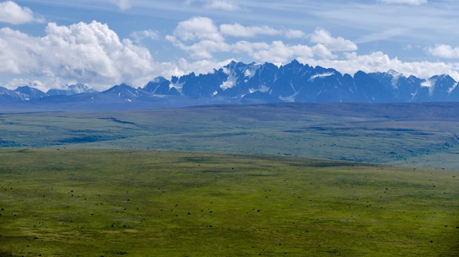 View of a vast landscape and highlands with mountains in the background.