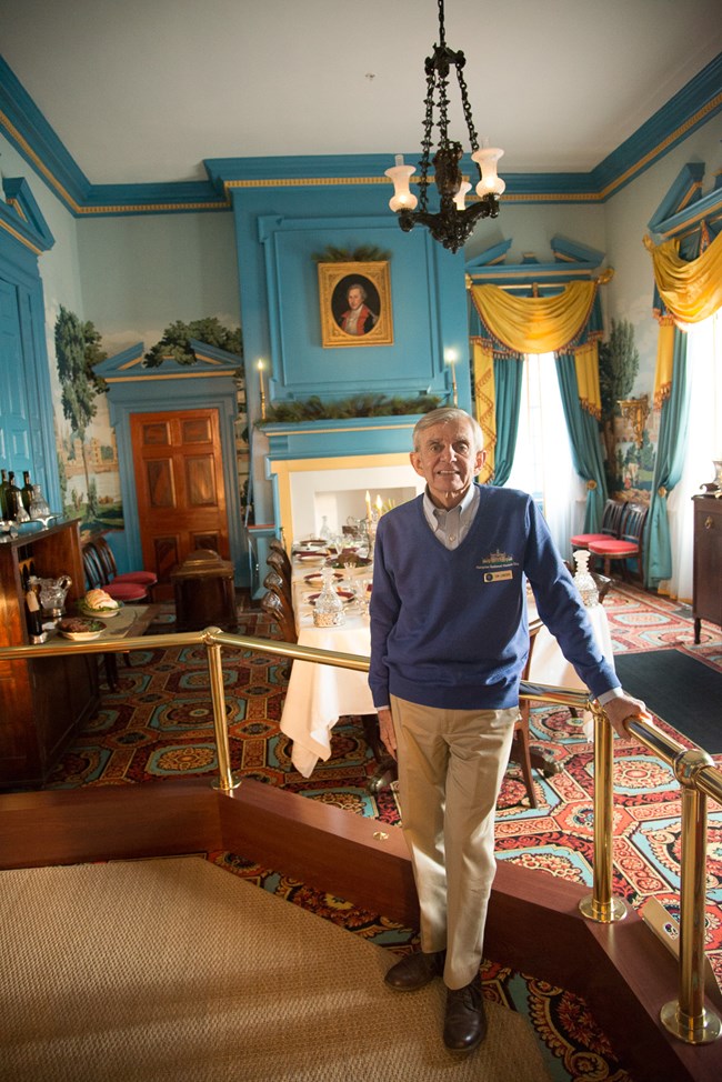 Man standing in Hampton mansion dining room. His name is Tom Lonegro.