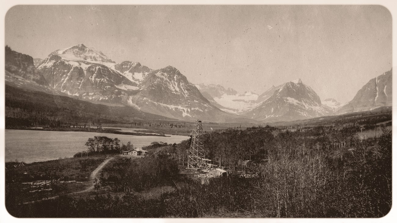 Drilling an oil well by Sherburne Lake with the Many Glacier valley in the background.