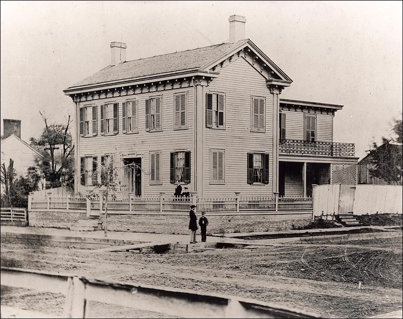 Two story house surrounded by dirt road. (Courtesy Abraham Lincoln Presidential Library & Museum)