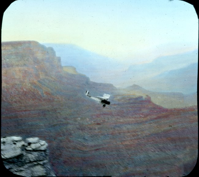 Old fashioned airplane flying above Grand Canyon.