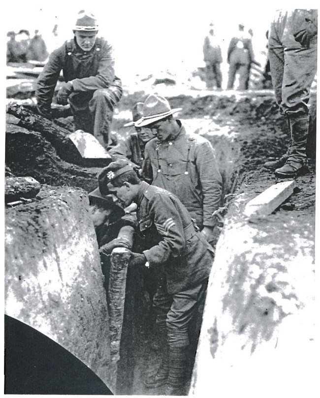 Instructor demonstrates proper trench reinforcement techniques for new recruits