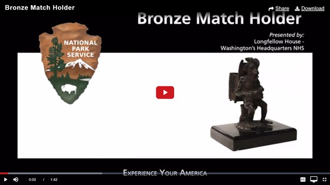 Screencap of a video, showing title "Bronze Match Holder" and a small bronze object.