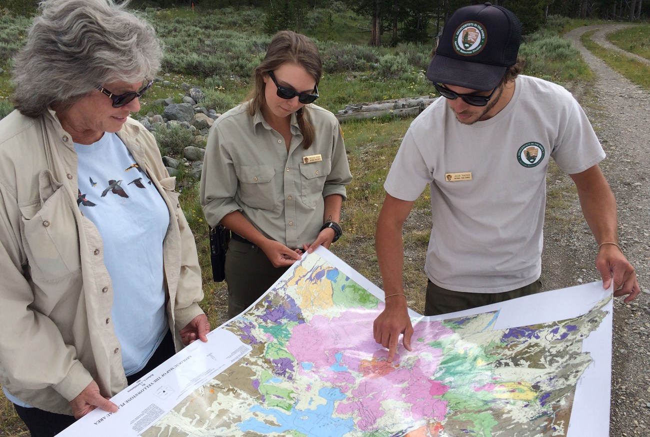 people examining a geologic map