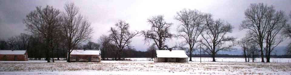 3 small white slave cabins in snow