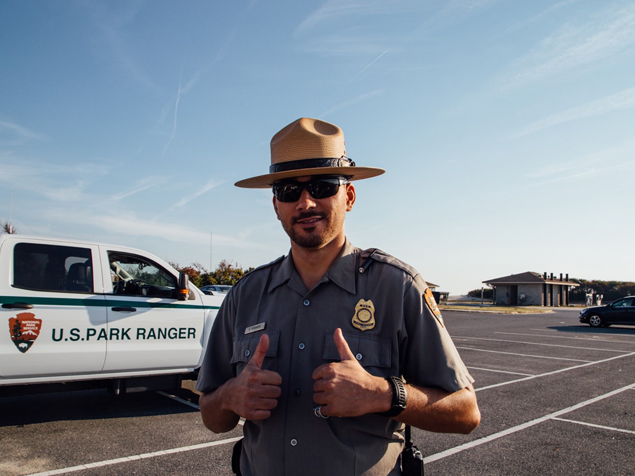 photo of Law Enforcement Ranger in front of National Park Service vehicle giving two thumbs up