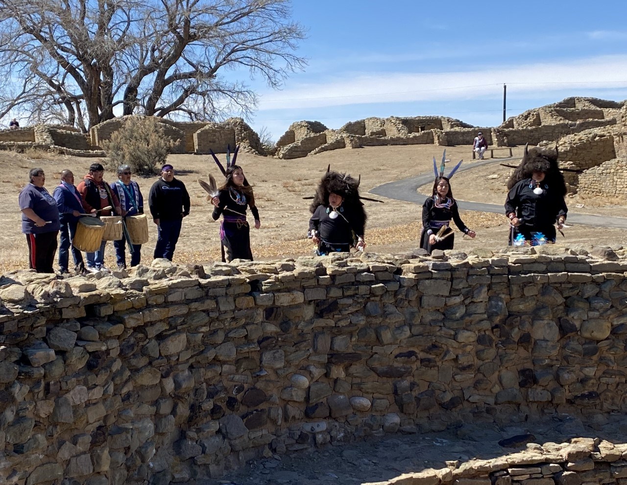 Drummers and dancers from the Acoma-Laguna Buffalo Dancers, performing a ceremony in the central plaza at Aztec West in spring 2022.