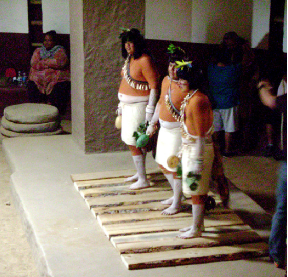 Modern Pueblo dancers preparing to pound boards placed over the floor vaults in the Great Kiva, using their feet to produce drumming sounds.