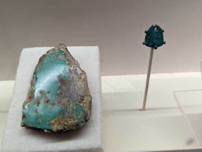 Raw turquoise along with a turquoise pendant on display at the Aztec Ruins museum.