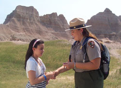 Ranger shaking the hand of a new Junior Ranger