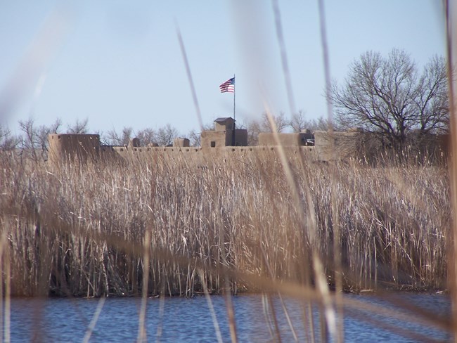 Wetland in foreground with Bent's Old Fort in background