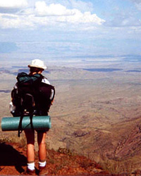 A solo hiker soaks in the view from the South Rim