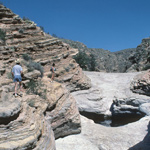 Hikers stand above the Ernst Tinaja