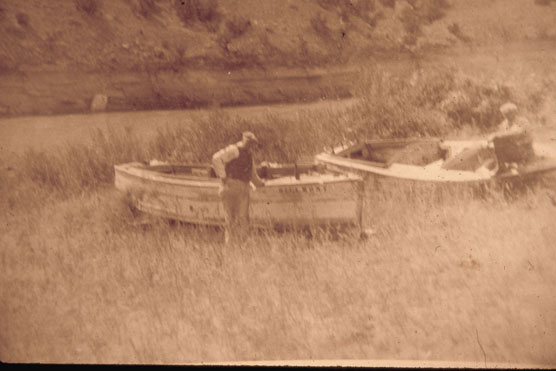 Man standing beside the Hillmont, a boat used to bring dudes to the Cedarvale Ranch