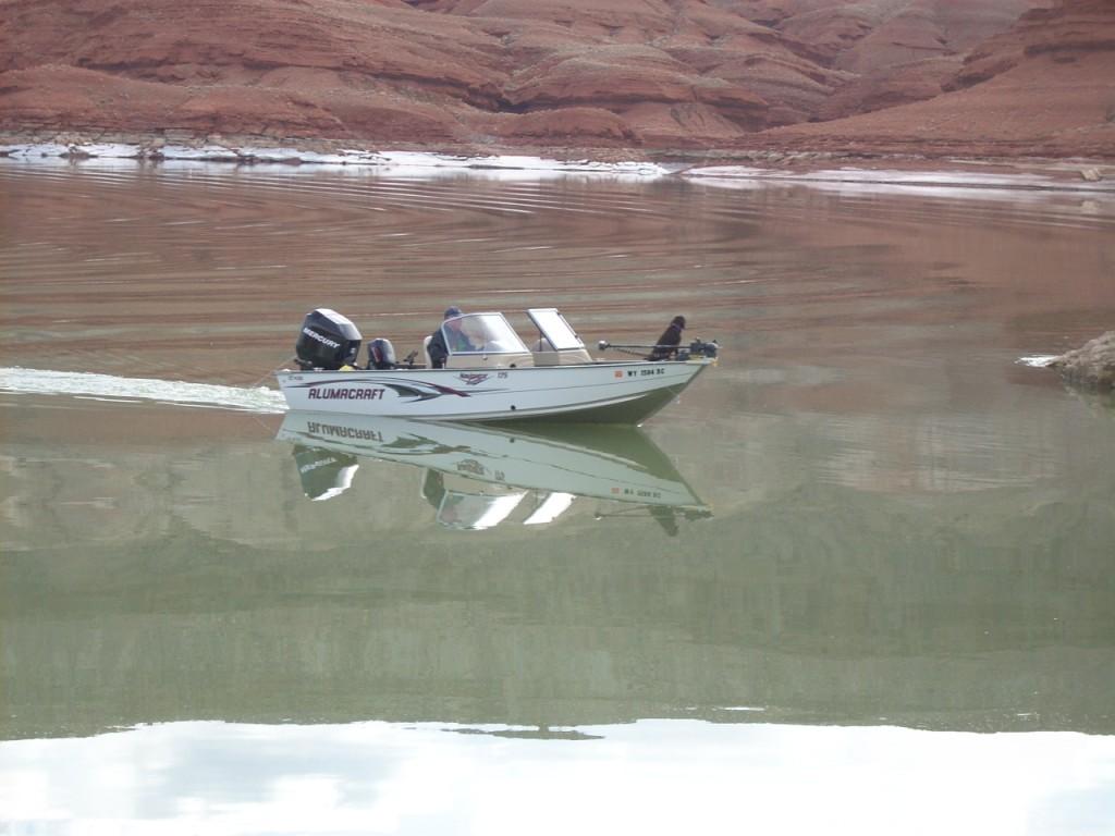 Fisherman in his boat at the red cliffs area near Horseshoe Bend