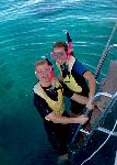 A man and a woman prepare to go snorkeling.