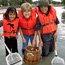 Three girls use dipnets and a glass bottom bucket to explore seagrass beds in the shallow bay waters off Elliott Key.