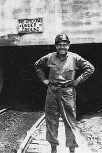 Cack Slaven stands in front of a mine opening.