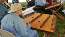 man with hat playing dulcimer with group