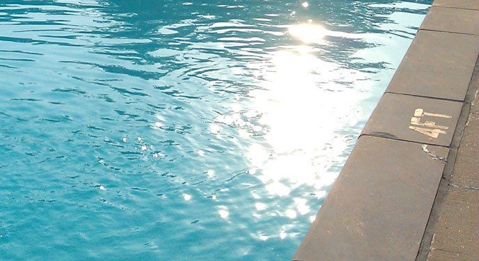 sunlight glistening off the water at edge of pool
