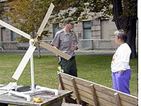 Photo of ranger and visitor with windmill model.