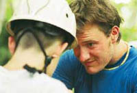 A climbing instructor prepares a student for his next challenge.