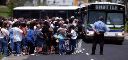 Image of people waiting for the oncoming shuttle buses.