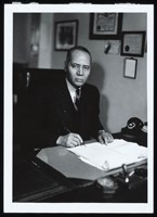 Charles Hamilton Houston, seated at desk. Photo, 1939.