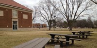 View of the four handicapped-accessible picnic tables looking towards the historic playground and the site.