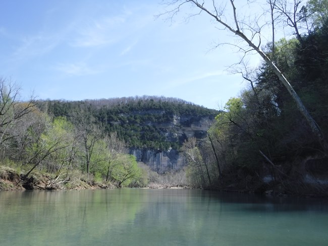 We paddle down a turquoise river toward a 500-foot-tall bluff in early spring.