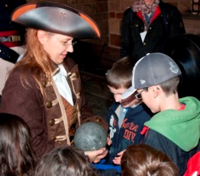 A ranger dressed as a privateer answers the questions of eager children.
