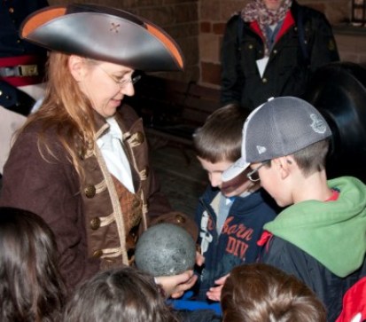 A ranger dressed as a privateer answers the questions of eager children. 
