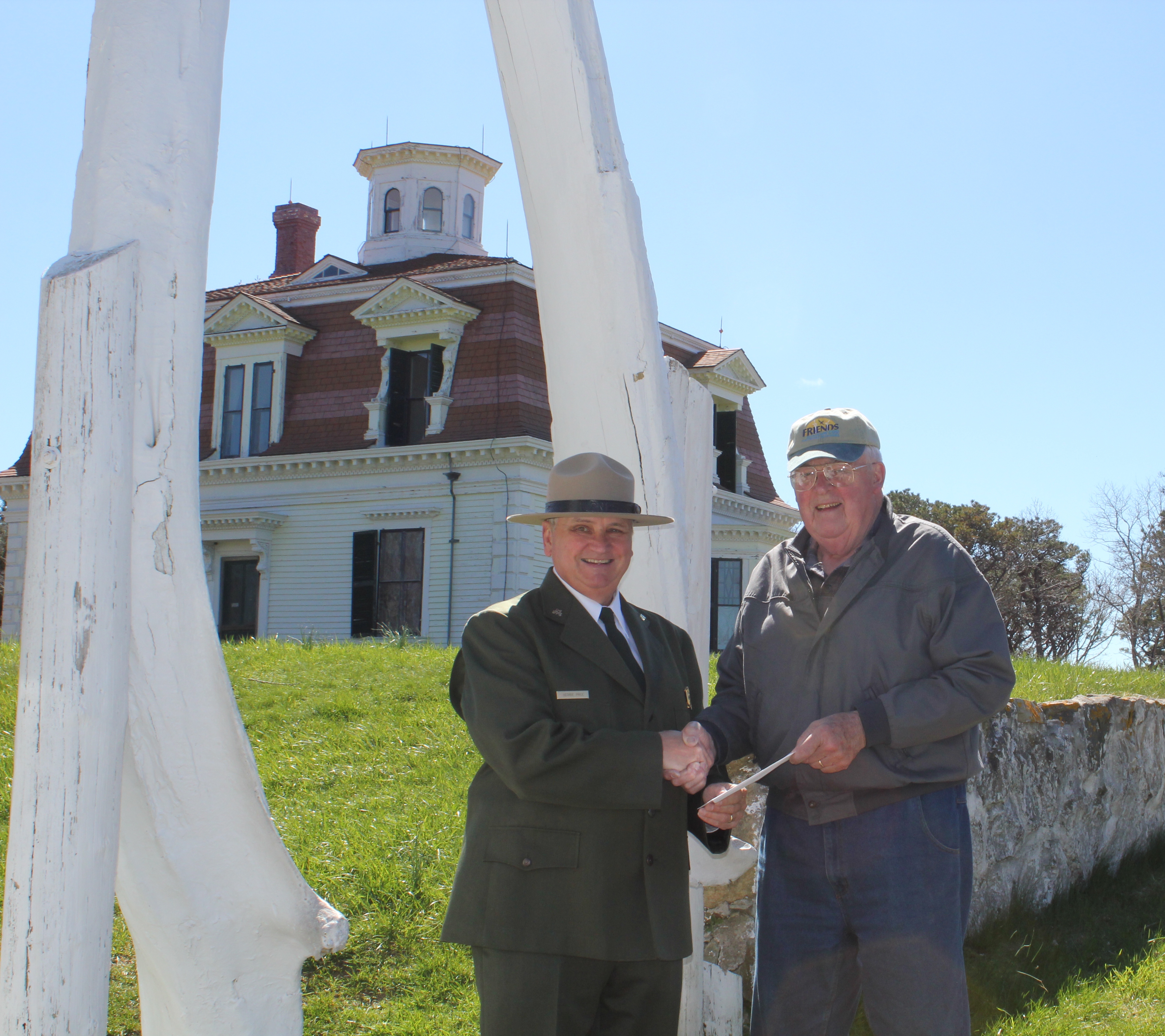 Richard G. Ryder, President of the Friends of Cape Cod National Seashore, hands Superintendent George Price a check for $100,000 as a partner match for the Centennial Challenge funding to repaint the Captain Edward Penniman House.
