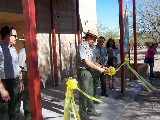 Superintendent Karl Cordova cuts yellow ribbon to open new visitor center addition