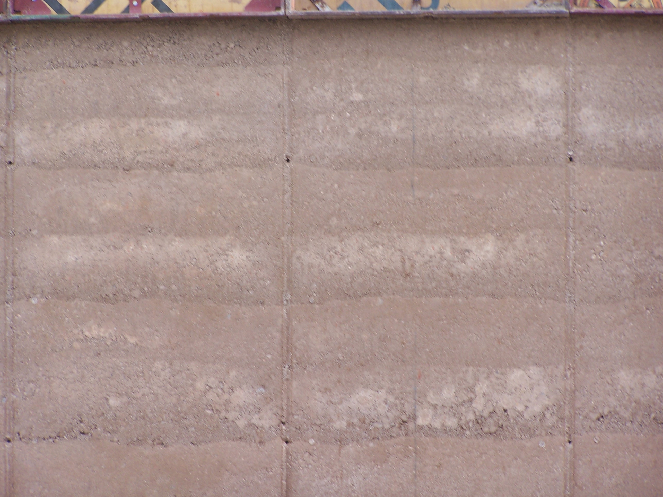 rammed earth wall close up shows layers in different shades of tan