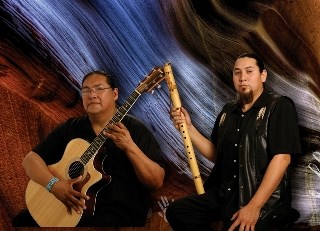 Aaron White andAnthony Wakemen pose in a studio with their guitar and flute