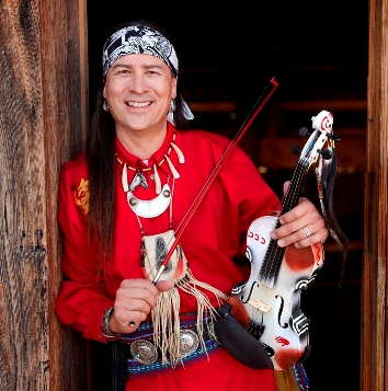 Arvel Bird standing in doorway holding fiddle