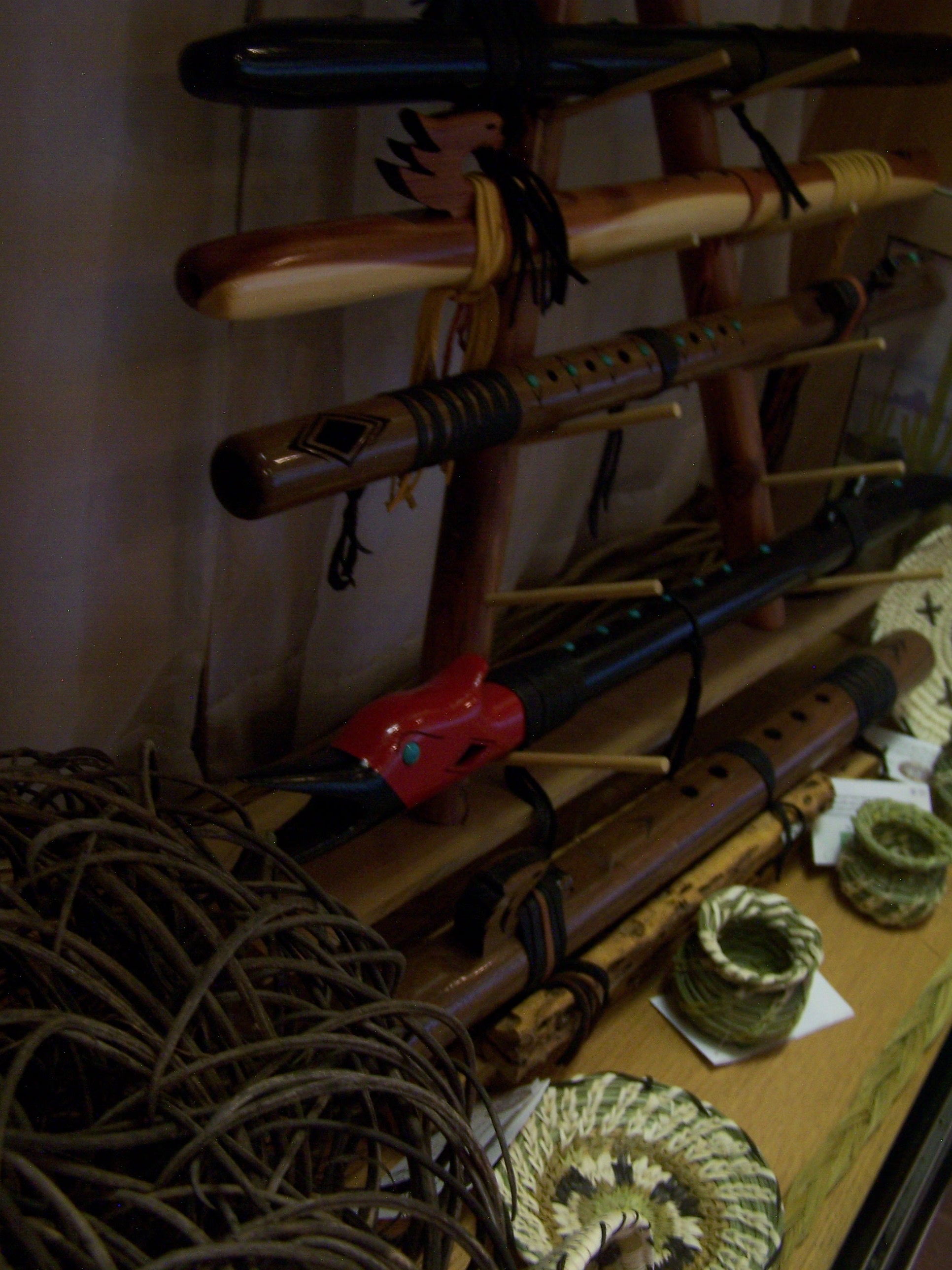 A rack of American Indian style flutes is bracketed by hand woven baskets in yucca and bear grass