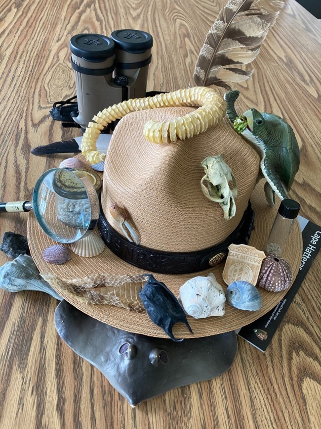 Ranger hat with various education items displayed on it.